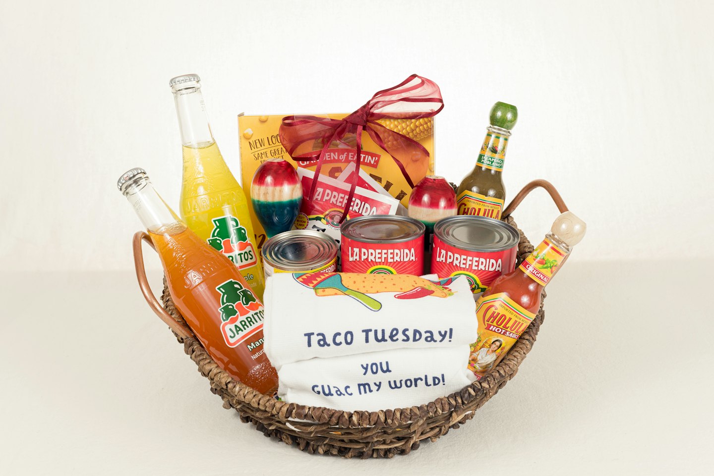 Una canasta de regalo tejida llena de comida y bebida mexicana.