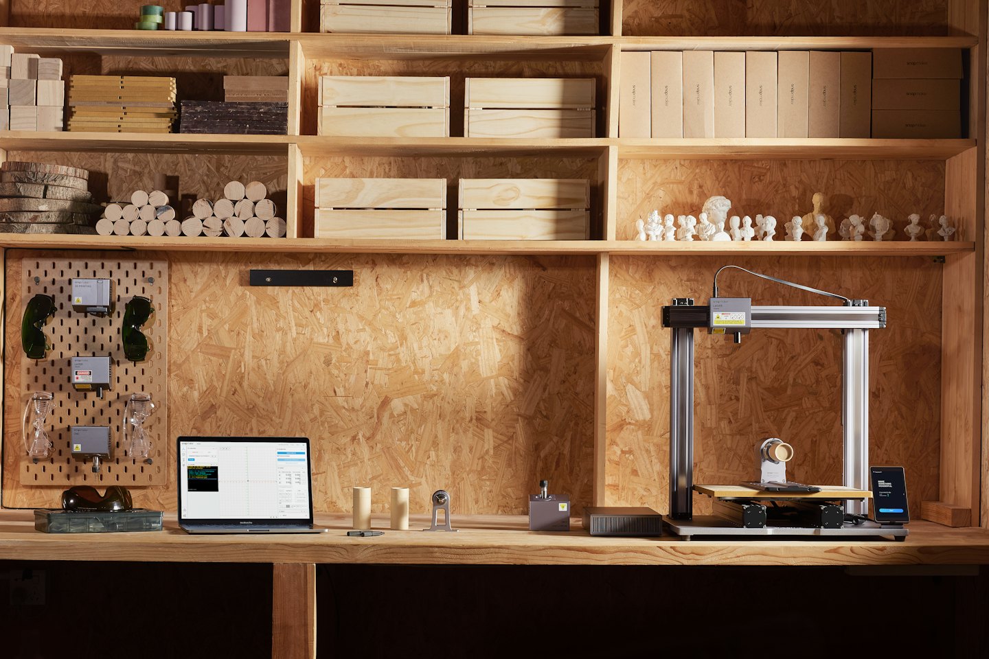 Grabador láser e impresora 3D en un banco de trabajo con portátil.